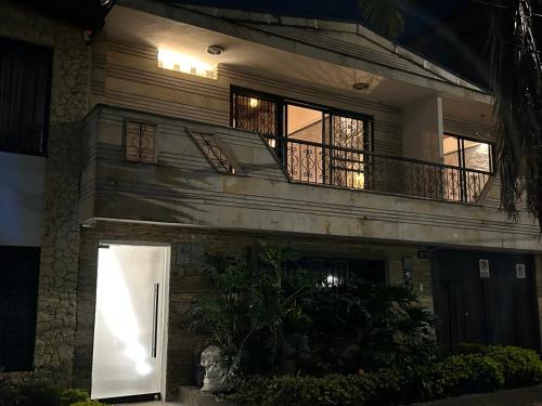 a house with a white door and a balcony at Casa Kyros Boutique in Medellín