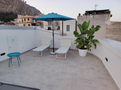a patio with two chairs and an umbrella on a roof at La Terrazza Del Sole di Mondello in Palermo