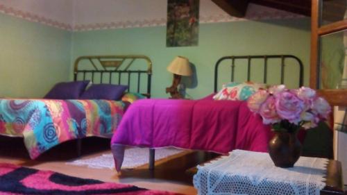 a bedroom with two beds and a vase of flowers at Antigua Posada, Valle del Jerte in Tornavacas