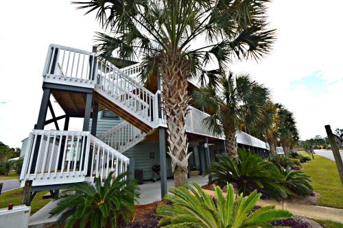 a house with a spiral staircase next to a palm tree at Bayview in Orange Beach