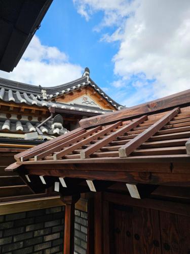 a wooden roof on a house with a building at SiEunJae in Gyeongju