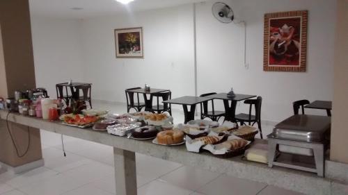 Hotel Vento Sul في تيكسيرا دي فريتاس: طاولة عليها انواع مختلفة من المعجنات