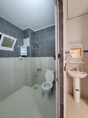 a bathroom with a toilet and a sink at Superbe Appartement bouki in Al Hoceïma