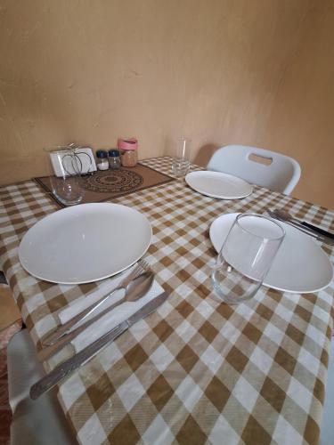 a table with plates and glasses on a checkered table cloth at Chelox Panama Airport in Tocumen