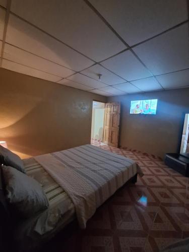 a bedroom with a bed with a tv on the wall at Chelox Panama Airport in Tocumen
