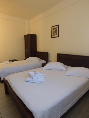 two beds in a hotel room with white sheets at Hotel Acropole in Bucharest