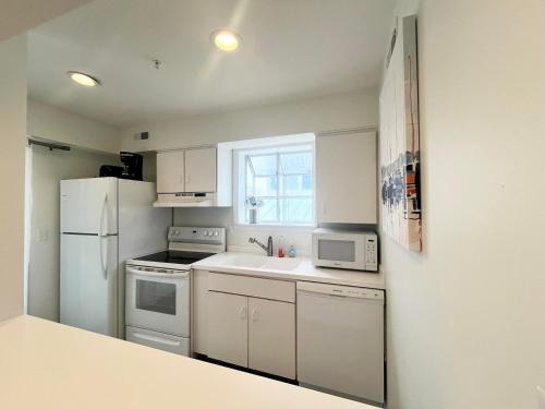 a small kitchen with white appliances and a window at Olive avenue 1a in Rehoboth Beach