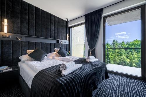 a bedroom with two beds and a large window at TATRAHOLIDAY - Apartament Mountain Pool & Spa in Białka Tatrzanska