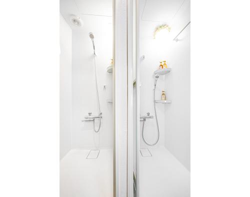 a white bathroom with a shower and a sink at 墨田区独栋三层别墅.晴空塔.浅草寺商圈.直达机场、涩谷。有室内小型停车位、无线网 in Tokyo