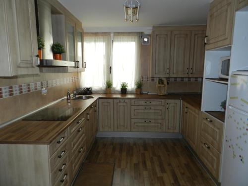 a kitchen with wooden cabinets and a white refrigerator at Sweet Home Santander in Santander