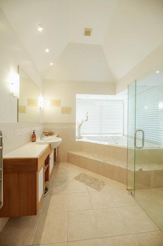 a bathroom with a tub and a sink and a shower at Russell Wharf House - Strand Apartment in Russell
