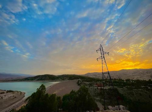 a electricity transmission tower on a hill next to a river at DAIFLAH Guesthouse & Hostel 