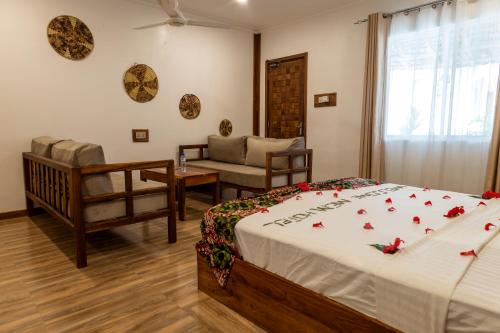 a bedroom with a bed and a couch and a chair at Mem Luxury Apartments and Hotel in Paje