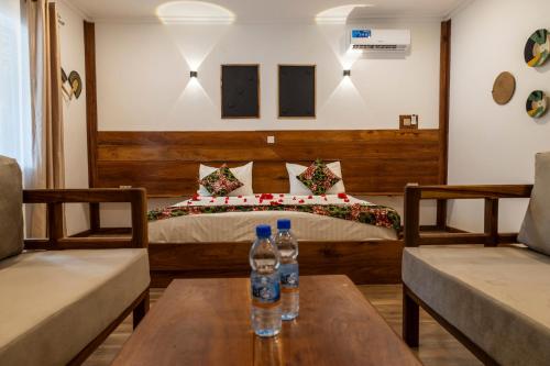 a bedroom with a bed with two bottles on a table at Mem Luxury Apartments and Hotel in Paje