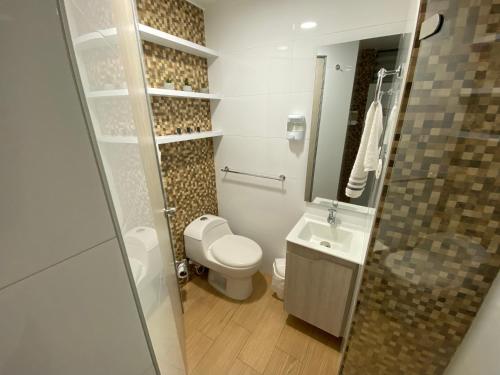 een kleine badkamer met toilet en wastafel bij comodidades en el centro de la ciudad in Manizales
