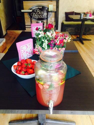 a jar of strawberries and a bowl of flowers at Pensiunea Bia Papadia in Bicaz