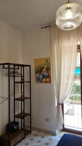 a living room with a chandelier and a window at Maison Chrilò, Sorrento in Sorrento