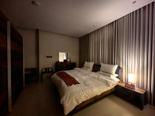 a bedroom with a large bed and a large window at UNDD Rouge in Jeddah