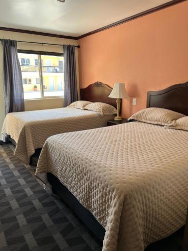 ein Hotelzimmer mit zwei Betten und einem Fenster in der Unterkunft DURAZNO INN in Nuevo Casas Grandes