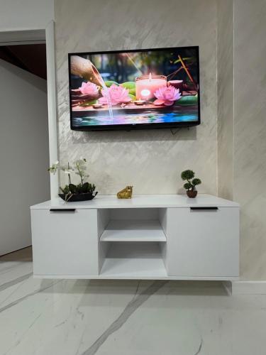 un centro de entretenimiento blanco con TV en la pared en Mona lux, en Novi Sad