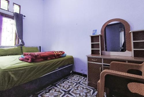 a bedroom with a bed and a mirror and a dresser at Elen Homestay by ABM in Bromo