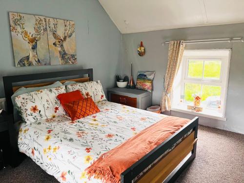 a bedroom with a bed with orange pillows and a window at Daffodil Lodge in Sligo