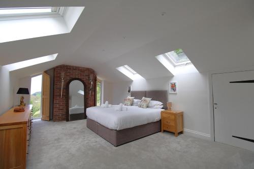 a bedroom with a bed in a room with skylights at Luxury secluded coastal retreat - With hot tub in Ilfracombe