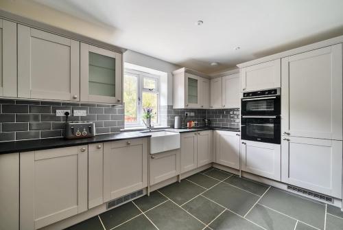 a white kitchen with white cabinets and appliances at Luxury secluded coastal retreat - With hot tub in Ilfracombe