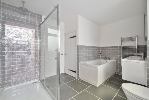 a bathroom with a tub and a sink and a toilet at Luxury secluded coastal retreat - With hot tub in Ilfracombe