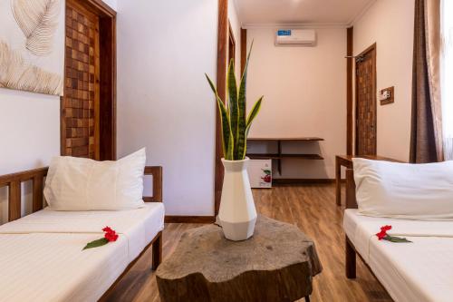 a room with two beds and a vase on a table at Mem Luxury Apartments and Hotel in Paje
