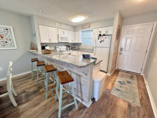 a kitchen with a large counter and a refrigerator at Bayview in Orange Beach