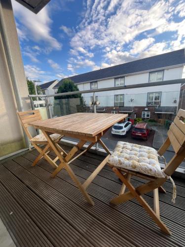 a wooden picnic table and a bench on a balcony at Bright Spacious Apartment in Dublin