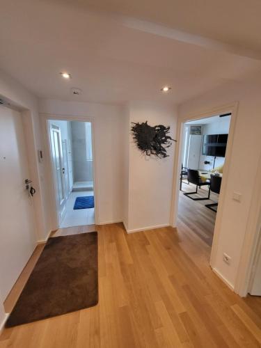 an empty living room with white walls and wood floors at TheOak Suite-Englischer Garten 2 Zimmer Apartment & Privat Parking in Munich
