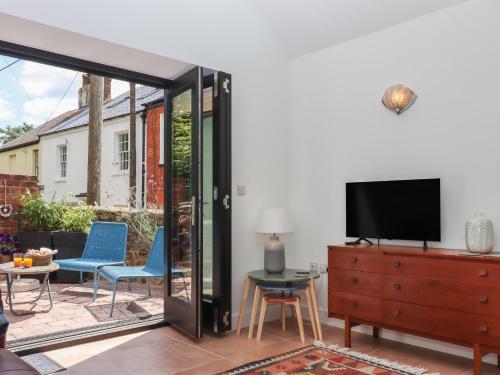 a living room with a tv and a sliding glass door at Jams in Exmouth