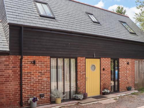 a red brick house with a yellow door at Jams in Exmouth