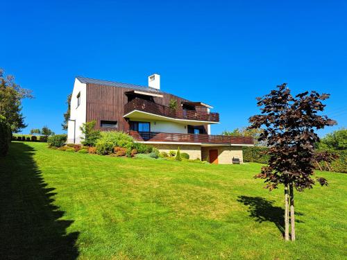 a house on a hill with a tree in the foreground at Apartmány Hutisko 769 in Hutisko