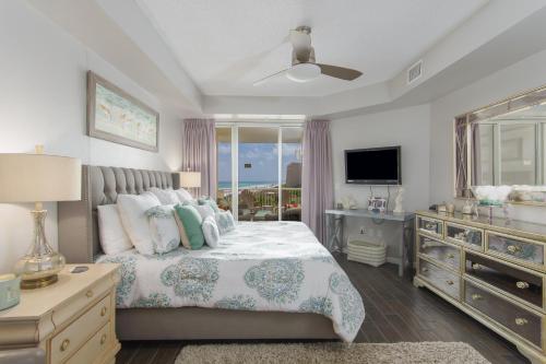 a bedroom with a bed with a television and a dresser at Crescent at Miramar-Gulf Front Luxury Condo-Free Beach Chairs! in Destin