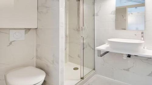 a white bathroom with a toilet and a sink at Alpine Casa Vacanze Domenion Livigno in Livigno
