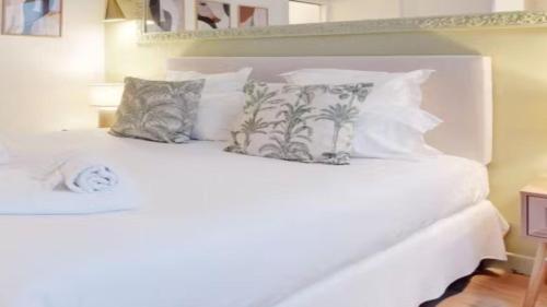 a white bed with some pillows on it at Alpine Casa Vacanze Domenion Livigno in Livigno