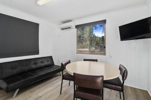 a living room with a table and a couch at Ingenia Holidays Murray Bend in Koonoomoo