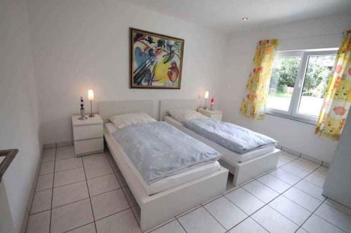 a bedroom with two beds and a picture on the wall at Apartment Rambin 1 in Rambin