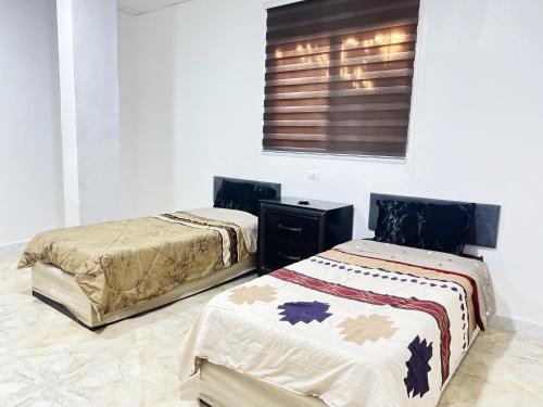 two beds sitting next to each other in a room at دار زمان Zaman Suites Old Town in Al Mafraq
