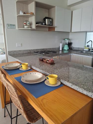 a kitchen table with two cups and plates on it at Apartamento Cartagena cerca a la playa in Cartagena de Indias