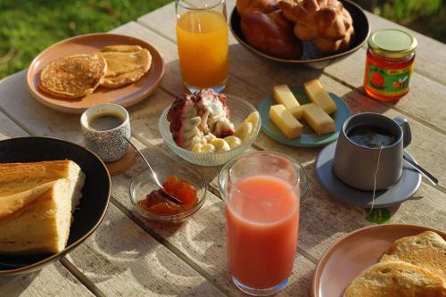 a wooden table with breakfast foods and drinks on it at L'Hacienda in Saint-Pierre