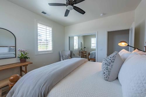 a bedroom with a white bed with a ceiling fan at Memory M Acres in Paso Robles