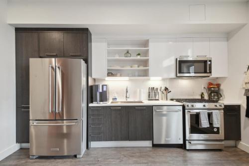 a kitchen with stainless steel appliances and wooden cabinets at Southwestern Charm | Espadin LoHi in Denver