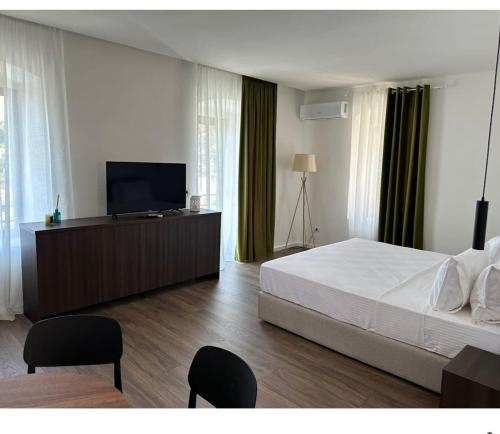 a bedroom with a bed and a flat screen tv at Milo's Villa in Dhërmi