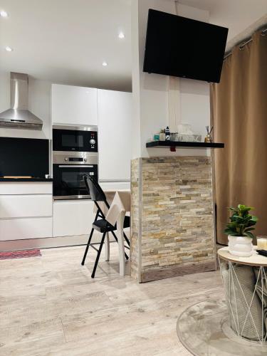 une cuisine avec des placards blancs et une cheminée en briques dans l'établissement Cosy T2 climatisé sur le port à 5min de la mer parking privé linge de bain et de lit fournis, à Port-Leucate