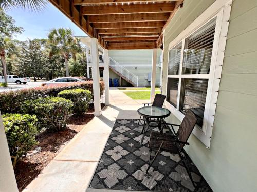 a patio with a table and chairs on a house at Laguna Breeze in Gulf Shores