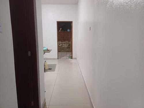 pasillo con paredes blancas y suelo de baldosa blanca en Casa de temporada PHN, en Cachoeira Paulista